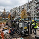 Construction cranes above apartment blocks being rebuilt in a Ukrainian city